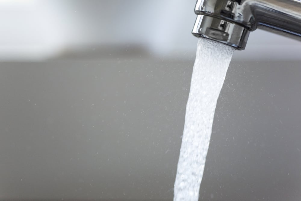 Water running from a tap into a kitchen sink